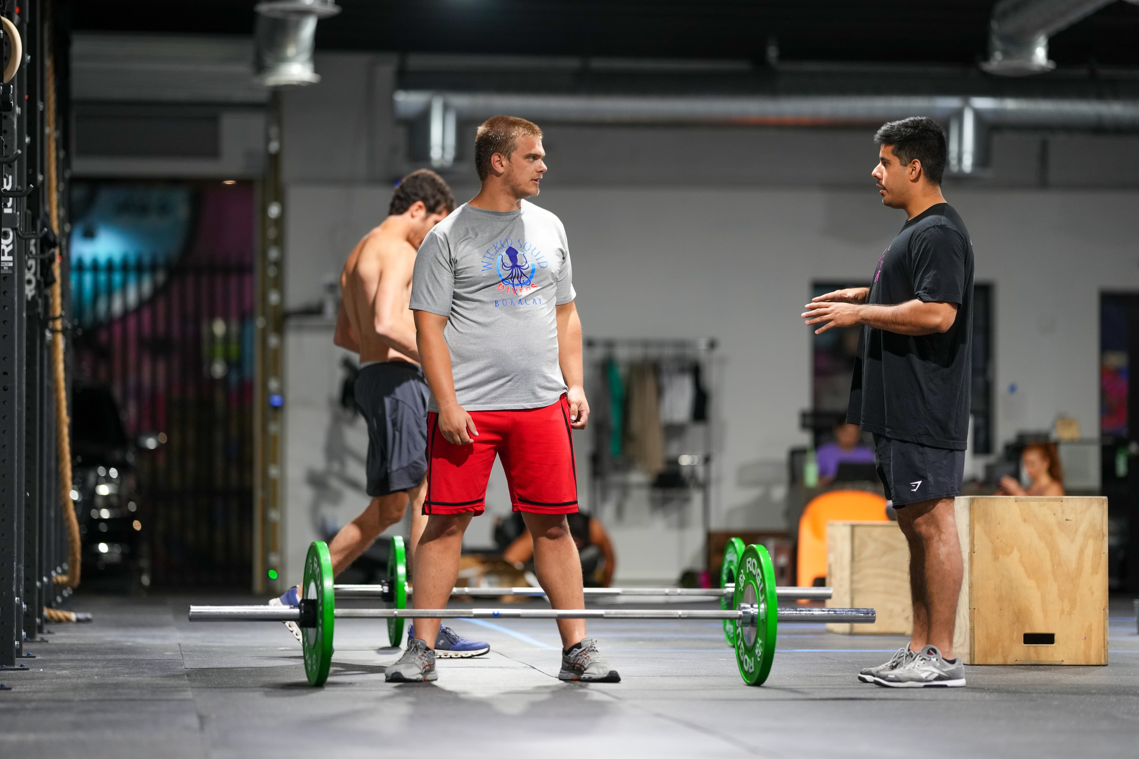 A Wynwood Fitness Club coach teaching an athlete technique during a HYROX training class in Miami